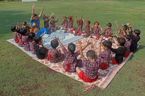 Pre primary students doing exercise on ground, india Stock Photos