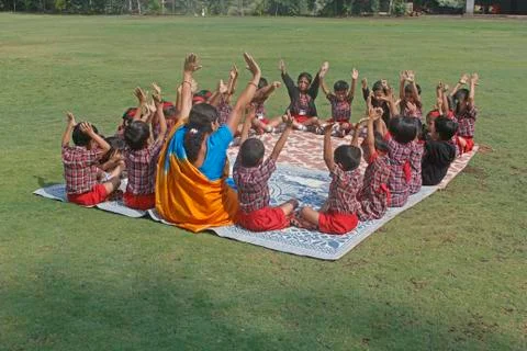 Pre primary students doing exercise on ground, india Stock Photos