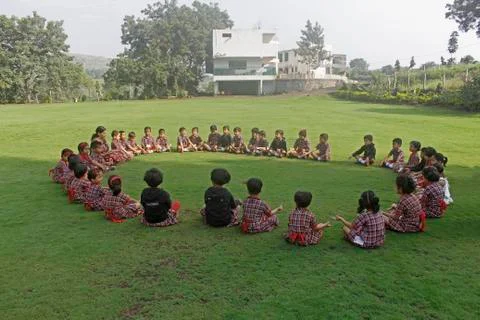 Pre primary students doing exercise on ground, india Stock Photos