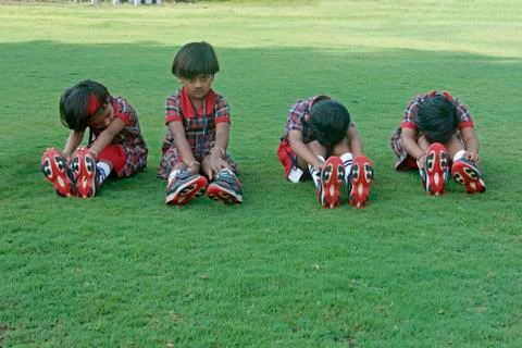 Pre primary students doing exercise on ground, india Stock Photos