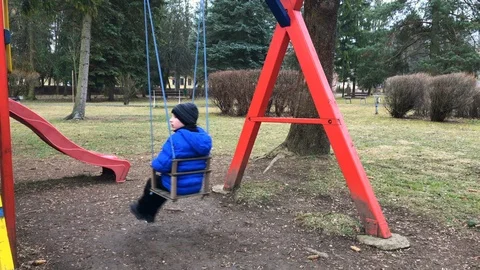 Pre-school age boy on swing in the park from behind Stock Footage 104218766