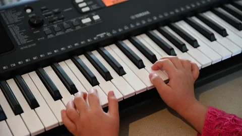 Pre school girl playing Yamaha Keyboard Stock Footage