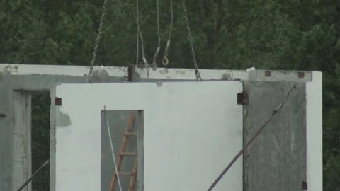 Precast concrete wall panel lifted by industrial chains, hooks on construction Stock Footage 328817861