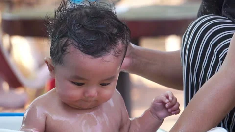 A precious moment of discovery during bath time as the baby learns about water  Stock Footage 302812486