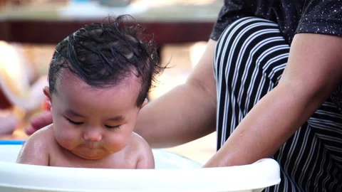 A precious moment of discovery during bath time as the baby learns about water  Stock Footage 302814035