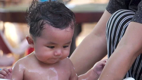 A precious moment of discovery during bath time as the baby learns about water  Stock Footage 302814477