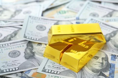Precious shiny gold bars on dollar bills Stock Photos