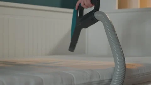Precise cleaning of mattress fabric with suction device by woman. Woman performs Stock Footage 341974174
