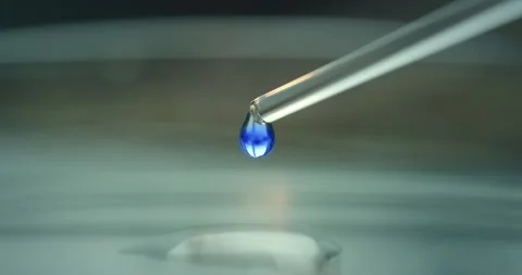 Precise drop of blue liquid is dispensed from a pipette Stock Footage 300362428