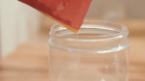 Precise hands transfer flour into container with expert control. Baker with Stock Footage 342335765