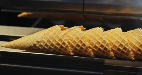 Precise robotized manipulator replaces crusty wafer cones at ice cream factory Stock Footage 346232178