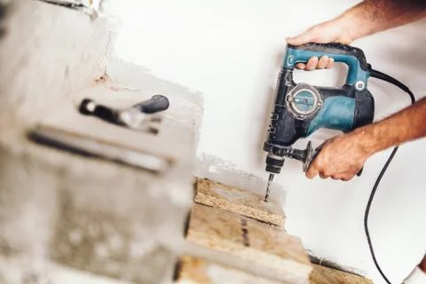 Precise wood worker using professional drill press for making holes in wood Stock Photos