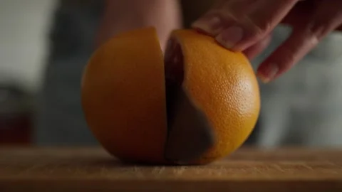 Precisely cutting a grapefruit with a large knife Stock Footage 314858328