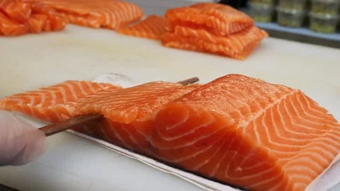 With precision and grace the chef slices fresh salmon into even pieces. The shar Stock Footage 284702056