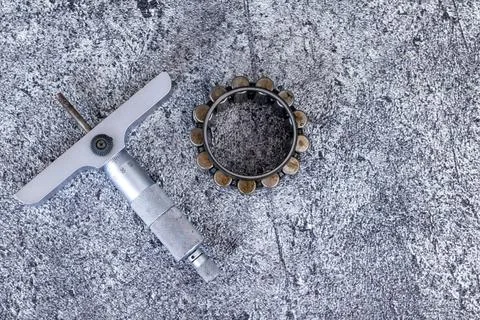 Precision depth micrometer gauge lying beside cylindrical roller bearing on.. Stock-Fotos
