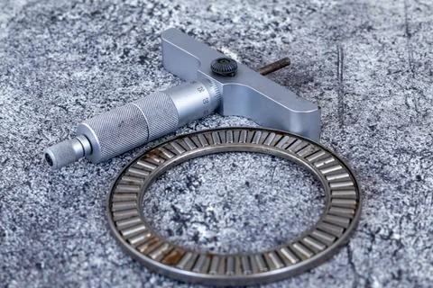 Precision depth micrometer gauge lying beside needle roller thrust bearing .. Photos