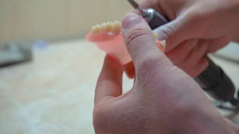 Precision grinding of a dental denture using a rotary tool 4K Stock Footage 304505983