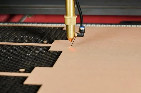 Precision laser cutting of cardboard sheets in an industrial box manufacturing Stock Photos