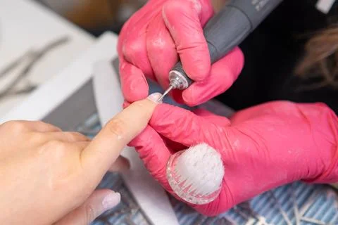 Precision manicure using a nail drill at a beauty salon Stock Photos