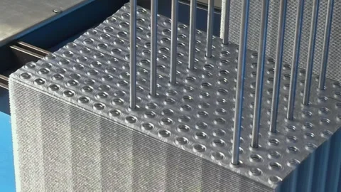 Precision Metal Rods Descending Into a Structured Grid Pattern in Daylight Stock Footage 340486398