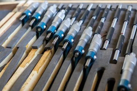 Precision micrometer tools and calibration rods lie stored in a wooden box .. Stock Photos