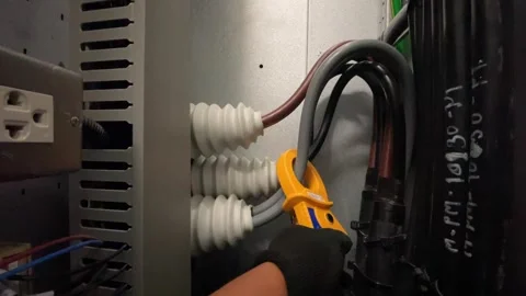 Precision in Power: Electricians Analyzing Current with Amp Clips Stock Footage 246994147