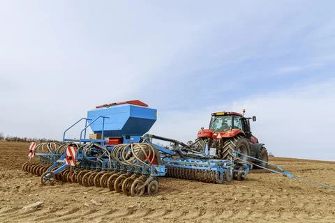Precision seeder attached to the tractor. Sowing grain crops in the field. Stock Photos