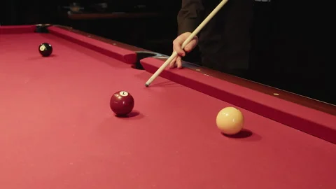 Precision shot moves balls across felt, player executes calculated hit 库存影片 329192799