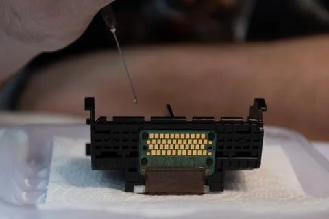Precision Work on Electronic Component With Dropper in Technicians Hands at Stock Photos