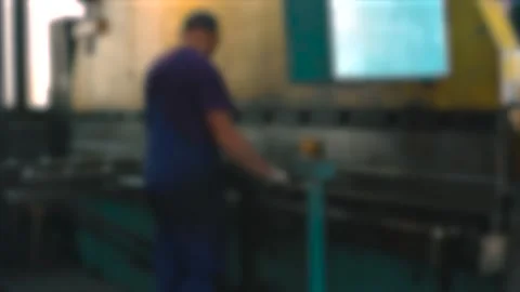 Precision work on a press brake in a bustling manufacturing facility Stock Footage 306395420