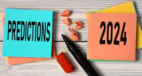 PREDICTIONS 2024 - words on multi-colored sheets on a light wooden background Stock Photos