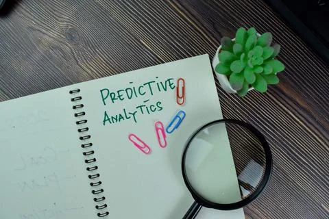 Predictive Analytics write on a book isolated on Wooden Table. Stock Photos
