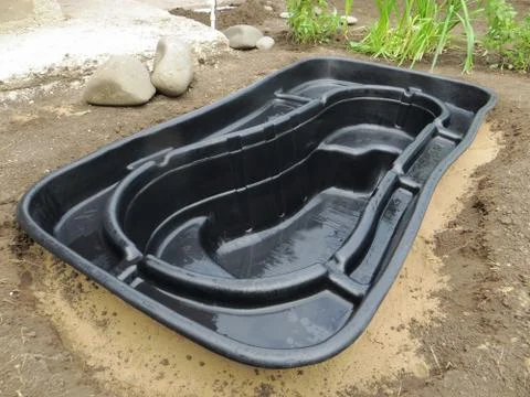 Preformed plastic pond insert installation in a dug stepped hole Stock-Fotos