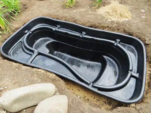 Preformed plastic pond insert installation in a dug stepped hole Stock-Fotos