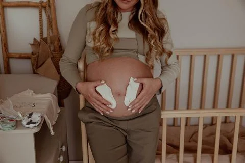 Pregnancy bally close up with tiny socks Stock Photos