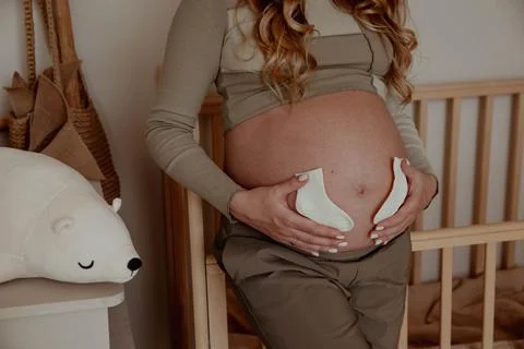 Pregnancy bally close up with tiny socks Stock Photos