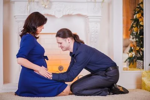 Pregnancy young couple on sofa Stock Photos