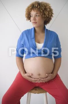 Pregnant African woman with hands on belly Stock-Fotos