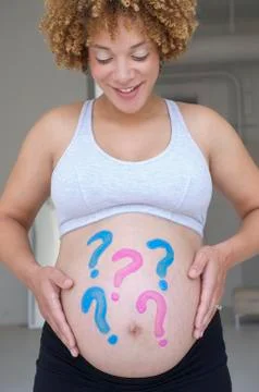 Pregnant African woman with question marks painted on belly Stock Photos