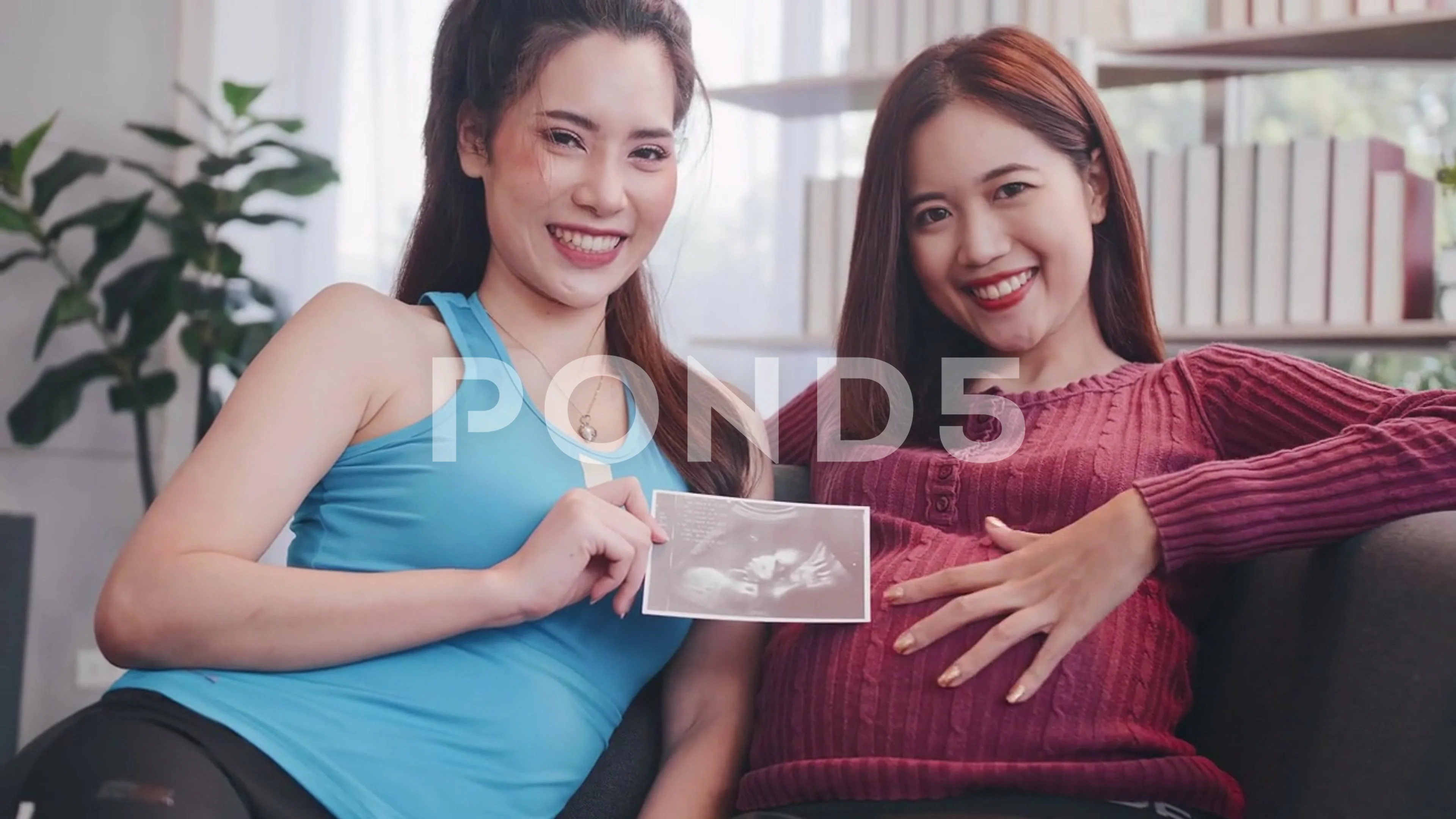 Pregnant Asian lesbian woman and her partner are happy to spend time  together