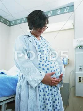 Pregnant Asian woman in hospital gown Stock Photos