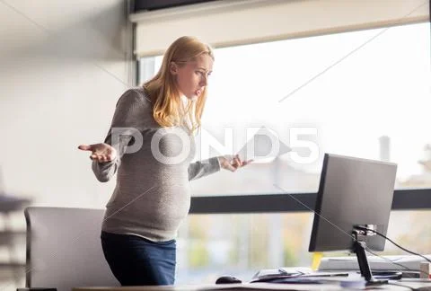 Pregnant businesswoman stressing at office work Stock Photos