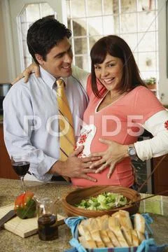 Pregnant Hispanic couple hugging Stock Photos