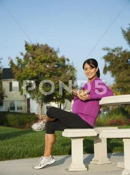 Pregnant Hispanic woman eating fruit salad Stock Photos