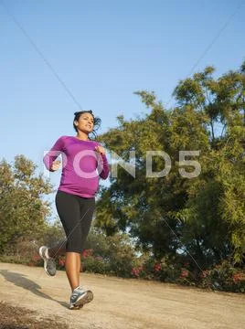 Pregnant Hispanic woman jogging outdoors Stock Photos