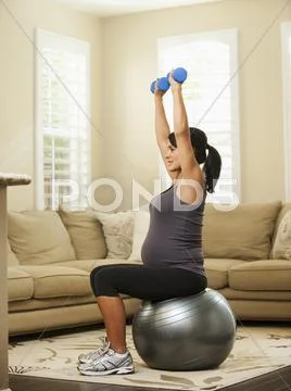 Pregnant Hispanic woman lifting weights Stock Photos