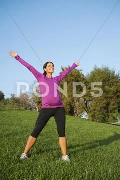 Pregnant Hispanic woman stretching outdoors Stock-Fotos