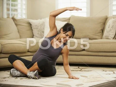 Pregnant Hispanic woman stretching Stock Photos