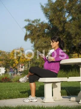 Pregnant Hispanic woman using cell phone Stock Photos