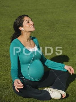 Pregnant Middle Eastern Woman Practicing Yoga In Park
